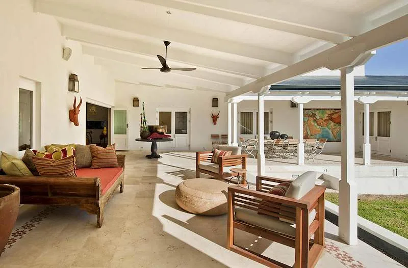 An open-air villa lounge faces a pool and the Franschhoek mountains.