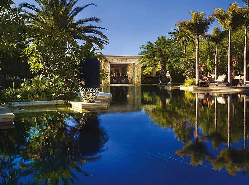 The resort’s lagoon-style pool sits among tropical palms at One&Only Cape Town.