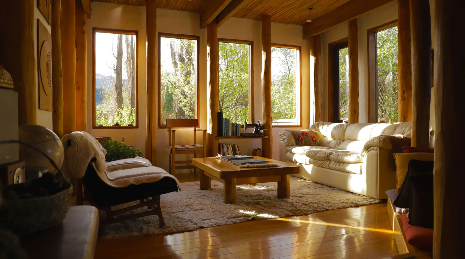 A bright wood-paneled sitting room with lounge chairs and broad windows.