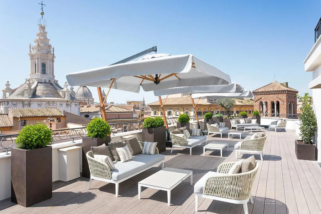A furnished rooftop terrace with a view of Rome’s Pantheon.