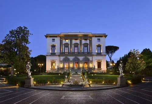 Villa Cora’s illuminated neoclassical façade and formal gardens at dusk.