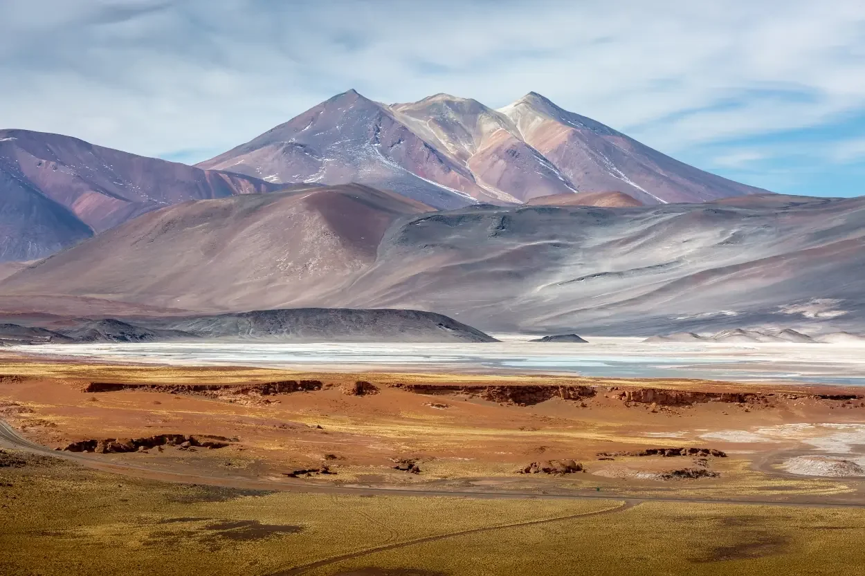 Colourful desert mountains rising above an open plain.