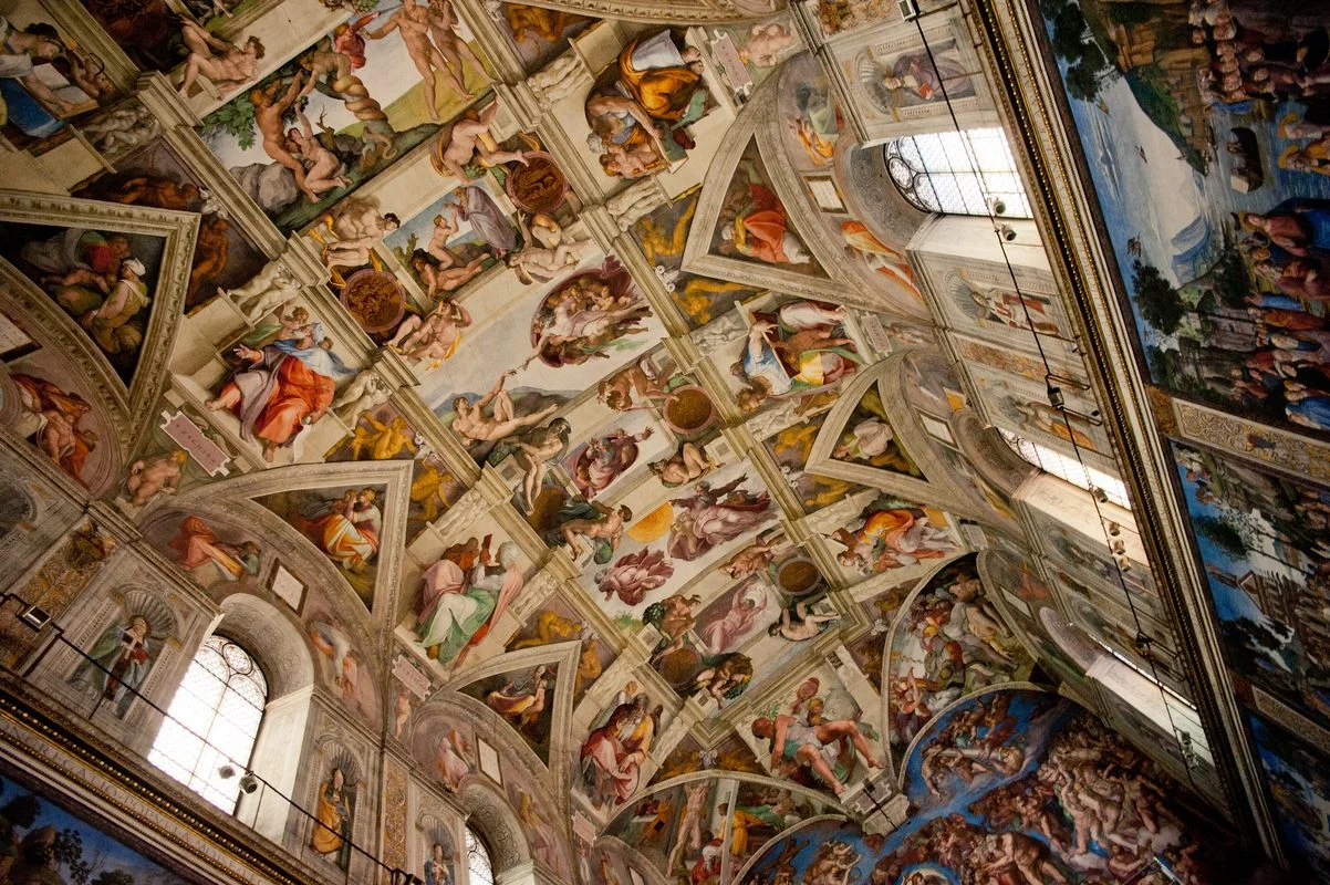 The Sistine Chapel's fresco-covered ceiling and tall windows.