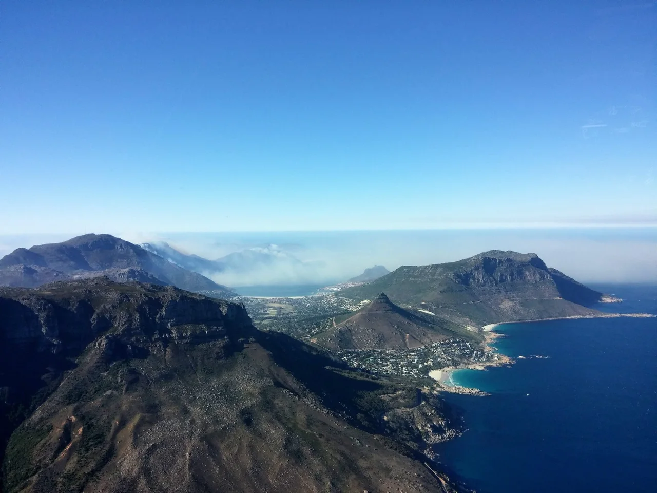 Aerial view of a mountainous coastline and blue ocean.
